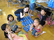 図2-1　PETボトルのオブジェ制作。学生の制作指導をうける小学生たち。