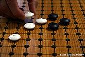 図1　視覚障害者用囲碁の例1。碁盤上の丸穴に石のスタッドを差し込んで固定する。