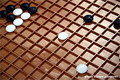 図2　視覚障害者用囲碁の例2.碁盤上の凸線を碁石裏面の溝で挟み込んで固定する。交点以外でも固定できてしまう。